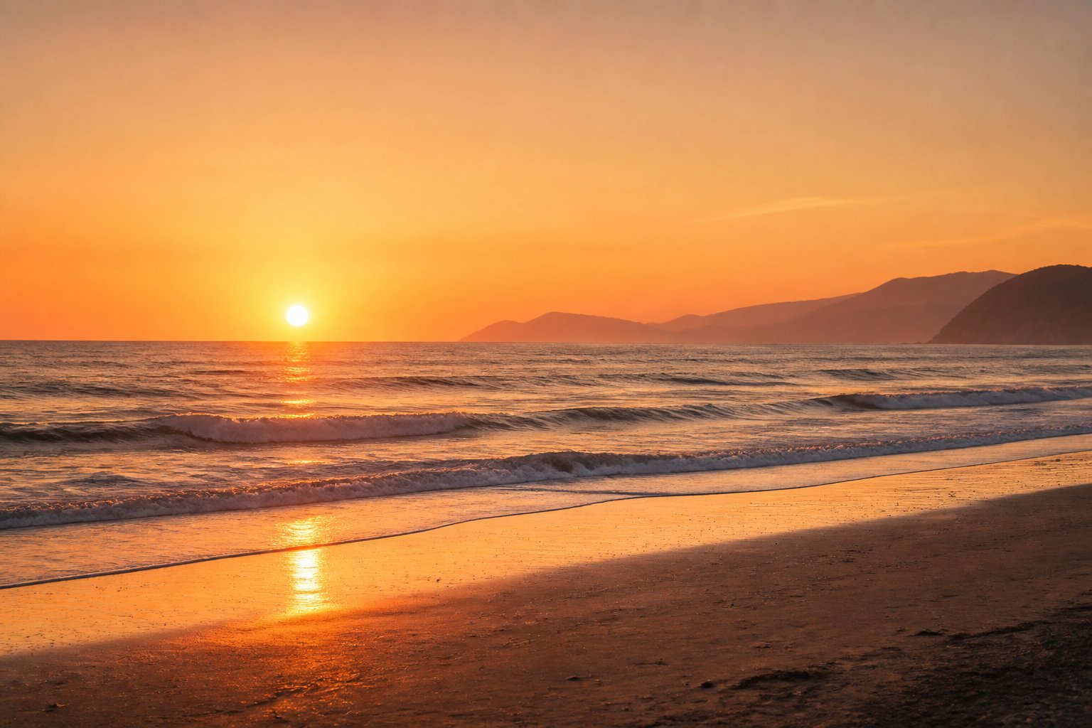 A golden sunrise over a calm ocean with distant mountains and a quiet shoreline.